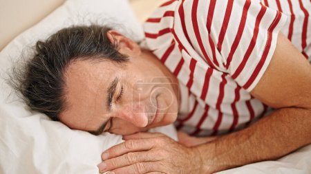 Photo for Middle age man lying on bed sleeping at bedroom - Royalty Free Image