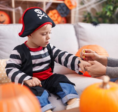 Photo for Adorable caucasian boy wearing pirate costume having draw on hand at home - Royalty Free Image