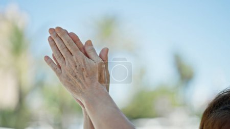 Téléchargez les photos : Femme d'âge moyen applaudissements mains à la rue - en image libre de droit