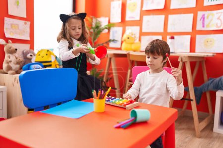 Photo for Adorable boy and girl playing xylophone and trumpet at kindergarten - Royalty Free Image