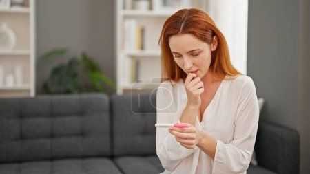 Photo for Young redhead woman waiting pregnancy test result at home - Royalty Free Image