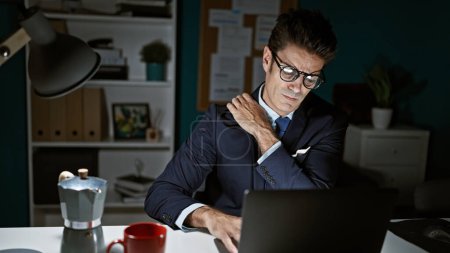 Photo for Young hispanic man business worker suffering for back pain working at the office - Royalty Free Image