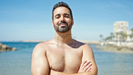 Photo for Young hispanic man tourist smiling confident standing shirtless with arms at the beach - Royalty Free Image