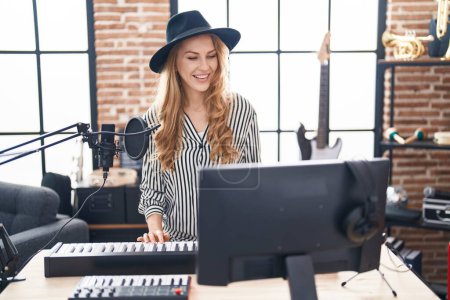 Téléchargez les photos : Jeune femme blonde musicienne jouant du piano clavier au studio de musique - en image libre de droit