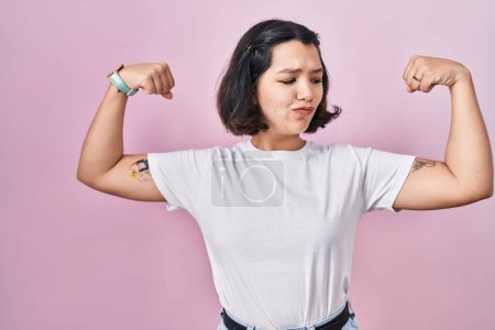 Photo for Young hispanic woman wearing casual white t shirt over pink background showing arms muscles smiling proud. fitness concept. - Royalty Free Image