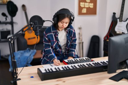 Foto de Mujer joven con síndrome de Down músico componiendo canción en el estudio de música - Imagen libre de derechos