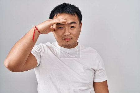 Photo for Young chinese man standing over white background worried and stressed about a problem with hand on forehead, nervous and anxious for crisis - Royalty Free Image