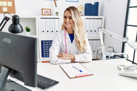Photo for Young woman wearing doctor uniform smiling confident at clinic - Royalty Free Image