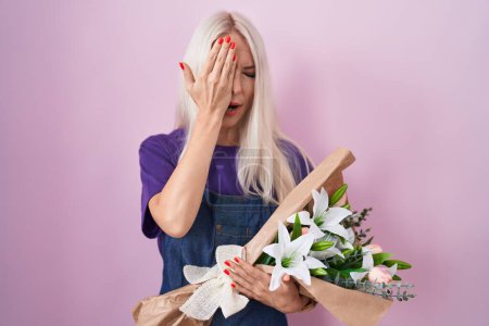 Photo for Caucasian woman holding bouquet of white flowers yawning tired covering half face, eye and mouth with hand. face hurts in pain. - Royalty Free Image