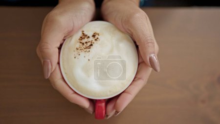 Foto de Joven mujer hispana hermosa sosteniendo una taza de café en casa - Imagen libre de derechos