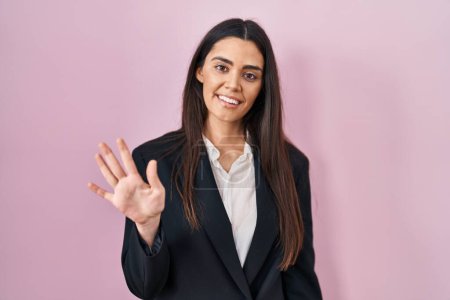 Photo for Young brunette woman wearing business style over pink background showing and pointing up with fingers number five while smiling confident and happy. - Royalty Free Image