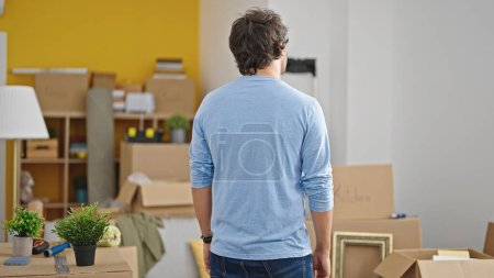 Photo for Young hispanic man standing backwards at new home - Royalty Free Image
