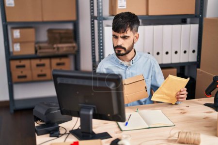 Téléchargez les photos : Jeune homme hispanique ecommerce business worker holding packages at office - en image libre de droit