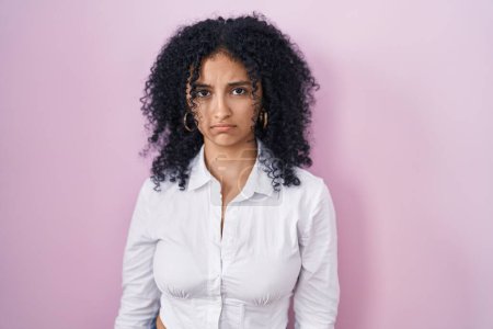 Photo for Hispanic woman with curly hair standing over pink background depressed and worry for distress, crying angry and afraid. sad expression. - Royalty Free Image