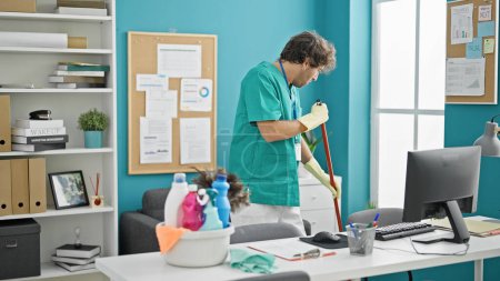 Photo for Young hispanic man professional cleaner cleaning floor at office - Royalty Free Image