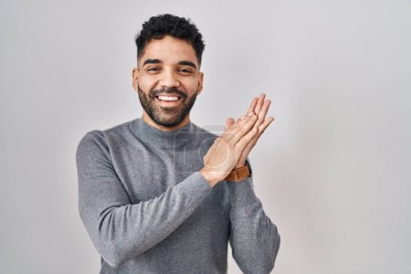 Téléchargez les photos : Hispanic man with beard standing over white background clapping and applauding happy and joyful, smiling proud hands together - en image libre de droit