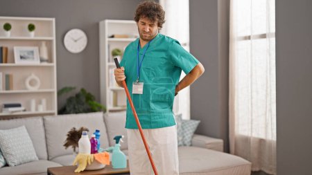 Photo for Young hispanic man professional cleaner cleaning floor suffering for backache at home - Royalty Free Image