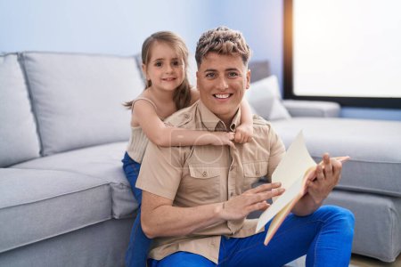 Photo for Father and daughter father and daughter reading book at home - Royalty Free Image
