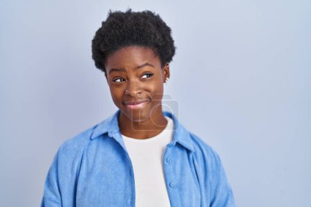 Téléchargez les photos : African american woman standing over blue background smiling looking to the side and staring away thinking. - en image libre de droit