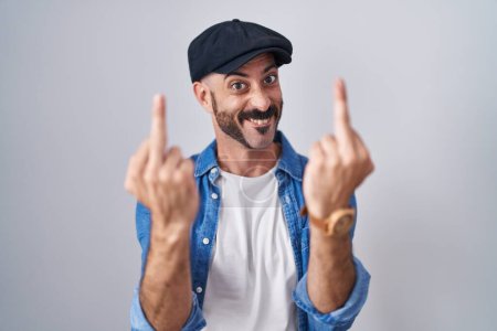 Foto de Hispanic man with beard standing over isolated background showing middle finger doing fuck you bad expression, provocation and rude attitude. screaming excited - Imagen libre de derechos