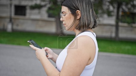Téléchargez les photos : Jeune belle femme hispanique utilisant un smartphone dans les rues de Vienne - en image libre de droit