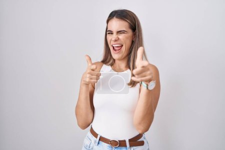 Photo for Hispanic young woman standing over white background pointing fingers to camera with happy and funny face. good energy and vibes. - Royalty Free Image