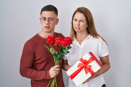 Photo for Mother and son holding mothers day gift clueless and confused expression. doubt concept. - Royalty Free Image