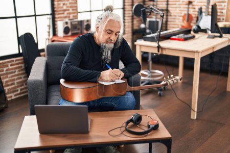 Téléchargez les photos : Moyen Age homme aux cheveux gris musicien compositeur de chanson au studio de musique - en image libre de droit