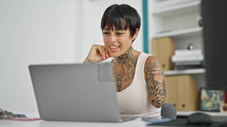 Téléchargez les photos : Femme hispanique avec un travailleur d'affaires amputé bras en utilisant un ordinateur portable travaillant au bureau - en image libre de droit