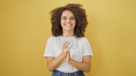 Téléchargez les photos : Jeune belle femme hispanique souriant mains claquement confiantes sur fond jaune isolé - en image libre de droit