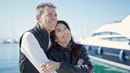 Téléchargez les photos : Senior homme et femme couple souriant confiant étreinte l'un l'autre au port - en image libre de droit