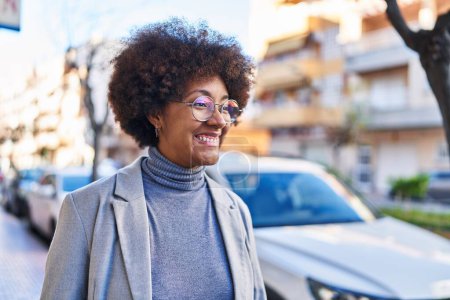 Téléchargez les photos : Afro-américaine femme exécutif souriant confiance debout à la rue - en image libre de droit