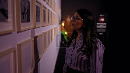 Photo for Young beautiful hispanic woman looking at art exhibition - Royalty Free Image