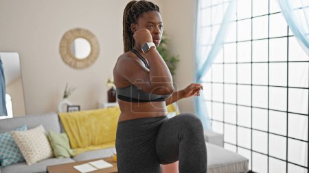 Téléchargez les photos : Femme afro-américaine portant des vêtements de sport formation à la maison - en image libre de droit