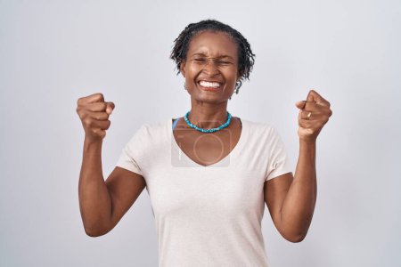 Photo for African woman with dreadlocks standing over white background excited for success with arms raised and eyes closed celebrating victory smiling. winner concept. - Royalty Free Image
