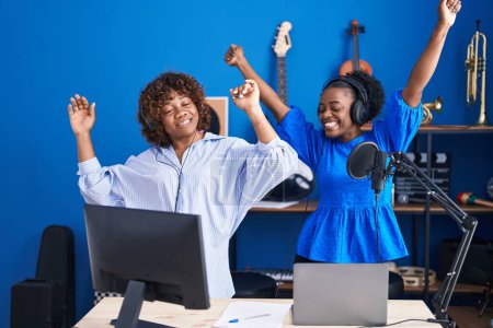 Téléchargez les photos : Musiciennes afro-américaines souriantes dansant avec confiance au studio de musique - en image libre de droit