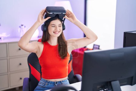 Téléchargez les photos : Young caucasian woman streamer smiling confident wearing virtual reality glasses at gaming room - en image libre de droit