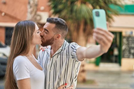 Foto de Hombre y mujer pareja hacer selfie por teléfono inteligente besos en la calle - Imagen libre de derechos