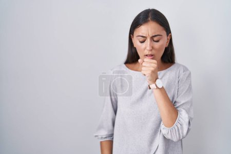 Téléchargez les photos : Jeune femme hispanique debout sur fond blanc se sentant mal et toussant comme symptôme de rhume ou de bronchite. concept de soins de santé. - en image libre de droit