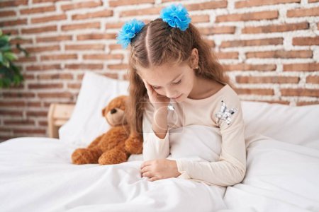 Photo for Adorable caucasian girl stressed sitting on bed at bedroom - Royalty Free Image