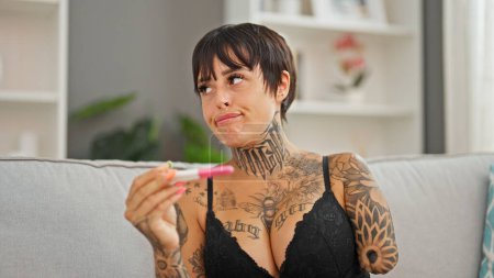 Téléchargez les photos : Femme hispanique avec bras amputé portant lingerie recherche test de grossesse à la maison - en image libre de droit