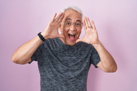 Photo for Middle age man with grey hair standing over pink background smiling cheerful playing peek a boo with hands showing face. surprised and exited - Royalty Free Image