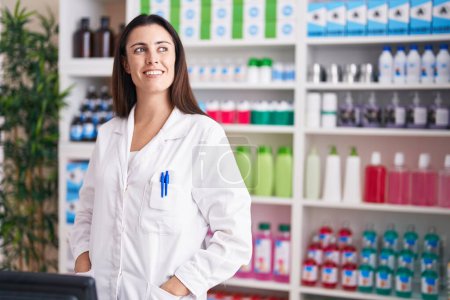 Photo for Young beautiful hispanic woman pharmacist smiling confident standing at pharmacy - Royalty Free Image