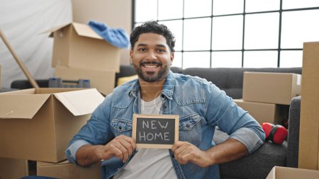 Photo for African american man smiling confident holding blackboard at new home - Royalty Free Image