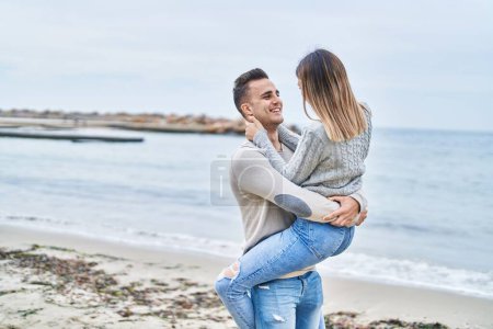 Photo for Man and woman couple hugging each other holding on arms at seaside - Royalty Free Image