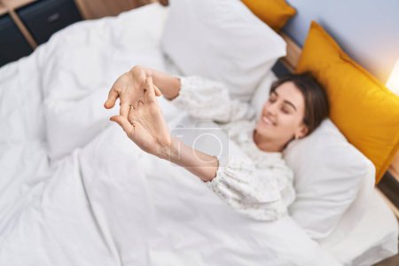 Photo for Young caucasian woman waking up stretching arms at bedroom - Royalty Free Image