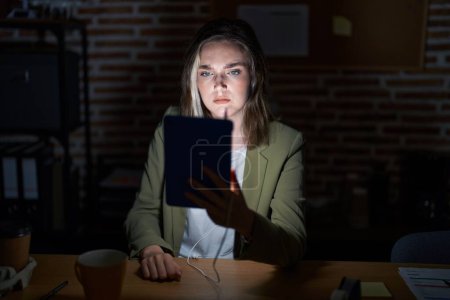 Photo for Blonde caucasian woman working at the office at night skeptic and nervous, frowning upset because of problem. negative person. - Royalty Free Image