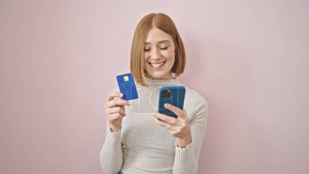 Photo for Young blonde woman shopping with smartphone and credit card over isolated pink background - Royalty Free Image