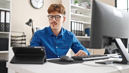 Téléchargez les photos : Jeune homme hispanique travailleur d'affaires en utilisant le pavé tactile et l'ordinateur au bureau - en image libre de droit