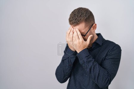 Téléchargez les photos : Jeune homme caucasien debout sur fond isolé avec une expression triste couvrant le visage avec les mains tout en pleurant. concept de dépression. - en image libre de droit